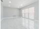 Bright living room with modern tile flooring and neutral wall colors, featuring large window and stylish blinds at 7015 Cobblewood Ct, Tampa, FL 33615
