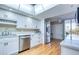 Updated kitchen with stainless appliances, white cabinetry, and wood floors next to dining at 7037 Sunset S Dr # 205, South Pasadena, FL 33707