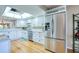 Modern kitchen with stainless steel refrigerator and white cabinets beneath a bright skylight at 7037 Sunset S Dr # 205, South Pasadena, FL 33707