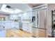 Modern kitchen with stainless steel refrigerator and white cabinets beneath a bright skylight at 7037 Sunset S Dr # 205, South Pasadena, FL 33707