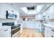 Bright kitchen with white cabinets, stainless steel appliances, and a skylight at 7037 Sunset S Dr # 205, South Pasadena, FL 33707