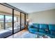 Living room features a blue couch, wood floors, and sliding glass doors leading to the outdoor patio at 7037 Sunset S Dr # 205, South Pasadena, FL 33707