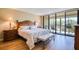 Serene main bedroom featuring a large bed, hardwood floors, and sliding glass doors to the balcony at 7037 Sunset S Dr # 205, South Pasadena, FL 33707