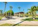 Outdoor picnic area with tables, grill, and shelter among palm trees at 7037 Sunset S Dr # 205, South Pasadena, FL 33707