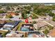 Aerial view of a residence featuring a screened-in pool, solar panels, and a convenient location near local amenities at 7428 Bramblewood Dr, Port Richey, FL 34668
