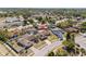 Aerial view of a residential neighborhood featuring a home with a screened-in pool, spacious yard, and mature trees at 7428 Bramblewood Dr, Port Richey, FL 34668