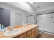 Bathroom featuring dual sinks, wood cabinets, and glass enclosed shower at 7428 Bramblewood Dr, Port Richey, FL 34668