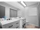 Modern bathroom with double vanity, large mirror, and a view of the toilet at 7428 Bramblewood Dr, Port Richey, FL 34668