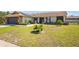 Inviting single-story residence with a stone facade, new solar panels, and well-kept lawn with young palm trees at 7428 Bramblewood Dr, Port Richey, FL 34668