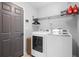 Laundry room features a new washer and dryer, storage shelves, and access to the garage at 7428 Bramblewood Dr, Port Richey, FL 34668