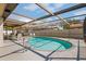 Outdoor screened-in pool with clear blue water, chairs and ladder to help relax and enjoy the hot days at 7428 Bramblewood Dr, Port Richey, FL 34668