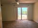 This bedroom features neutral carpeting and sliding door access to outdoor views at 7430 Sunshine Skyway S Ln # 305, St Petersburg, FL 33711