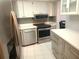 Bright kitchen with white cabinets, stainless steel appliances, and colorful tile backsplash at 7430 Sunshine Skyway S Ln # 305, St Petersburg, FL 33711