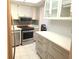 Updated kitchen with stainless appliances, white cabinets, and a convenient island counter at 7430 Sunshine Skyway S Ln # 305, St Petersburg, FL 33711