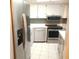 Galley kitchen featuring stainless steel appliances, white cabinets, and a bright, modern design at 7430 Sunshine Skyway S Ln # 305, St Petersburg, FL 33711