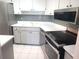 Well-lit kitchen boasting stainless steel appliances, white cabinets, and mosaic tile accents at 7430 Sunshine Skyway S Ln # 305, St Petersburg, FL 33711