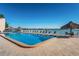 Sparkling waterfront swimming pool surrounded by seating, tiki huts and views of the ocean at 7430 Sunshine Skyway S Ln # 305, St Petersburg, FL 33711