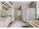 Bright bathroom featuring dual sinks, ample counter space, a shower and bathtub with modern lighting fixtures at 7850 Lake Placid Ln, New Port Richey, FL 34655