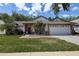 Charming single-story home with a two-car garage, landscaped yard, and inviting front porch at 7850 Lake Placid Ln, New Port Richey, FL 34655