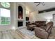 Inviting living room has wood floors, a cozy fireplace, and large windows for ample sunlight at 7850 Lake Placid Ln, New Port Richey, FL 34655