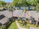 Aerial view of well-maintained condos with lush landscaping and community tennis courts in a serene setting at 90 S Highland Ave # 6, Tarpon Springs, FL 34689