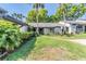 Charming single-story home with lush green lawn and mature tropical landscaping at 90 S Highland Ave # 6, Tarpon Springs, FL 34689