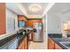 Well-lit kitchen featuring stainless steel appliances, wood cabinets, and elegant dark granite countertops at 90 S Highland Ave # 6, Tarpon Springs, FL 34689