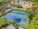 Aerial shot of community tennis courts surrounded by mature trees and well-maintained condo buildings at 90 S Highland Ave # 6, Tarpon Springs, FL 34689