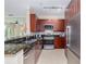 Modern kitchen with stainless steel appliances, granite countertops and dark wood cabinets at 2709 Via Cipriani # 522B, Clearwater, FL 33764