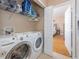 Laundry room with a washer and dryer, wire shelving, and an open doorway to the bedroom at 2709 Via Cipriani # 522B, Clearwater, FL 33764