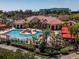 Stunning community pool featuring a sprawling sundeck, comfortable loungers, and lush tropical landscaping at 2709 Via Cipriani # 522B, Clearwater, FL 33764