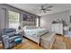 Spacious bedroom with a tufted headboard, ceiling fan and cozy sitting area at 10229 Avelar Ridge Dr, Riverview, FL 33578