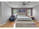 Comfortable bedroom with light gray walls, wood floors, and a ceiling fan at 10229 Avelar Ridge Dr, Riverview, FL 33578