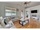 Bright living room featuring hardwood floors, a ceiling fan, and a sliding door to the backyard at 10229 Avelar Ridge Dr, Riverview, FL 33578