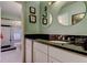 Bathroom features a vanity with black countertop, a round mirror, and tiled shower at 10601 42Nd N Ct, Clearwater, FL 33762