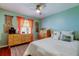 Bright bedroom with a ceiling fan, two dressers, colorful curtains, and area rug at 10601 42Nd N Ct, Clearwater, FL 33762