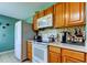 Well-lit kitchen with wooden cabinets, appliances, and a tile backsplash at 10601 42Nd N Ct, Clearwater, FL 33762
