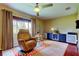 Sitting area has tan recliner chair, rug, ceiling fan, window, and dark wood floors at 10601 42Nd N Ct, Clearwater, FL 33762