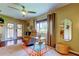 Sitting area has tan recliner chair, rug, ceiling fan, and french doors to the backyard at 10601 42Nd N Ct, Clearwater, FL 33762