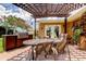 Covered patio has a BBQ, dining table, chairs, decorative elements, and landscaping at 10601 42Nd N Ct, Clearwater, FL 33762