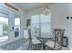 Cozy dining area features modern table, seating for four, and a view to outdoor grill area at 11309 Grand Park Ave, Riverview, FL 33578