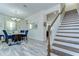 Bright dining room boasts modern chandelier, stylish decor, and seamless access to a staircase with hardwood floors at 11309 Grand Park Ave, Riverview, FL 33578