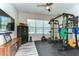 Well-equipped exercise room featuring a comprehensive weightlifting system, cardio machine, and ample natural light for workouts at 11309 Grand Park Ave, Riverview, FL 33578