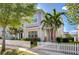 Charming two-story home featuring a picket fence, lush landscaping, and a welcoming entrance with beautiful palm trees at 11309 Grand Park Ave, Riverview, FL 33578