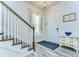 Bright foyer features hardwood floors, a staircase with white railings, and a classic console table beneath a decorative mirror at 11309 Grand Park Ave, Riverview, FL 33578