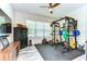 Bright, spacious gym features weight rack, rowing machine, TV, and sturdy black rubber flooring at 11309 Grand Park Ave, Riverview, FL 33578