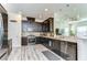 Modern kitchen features dark cabinets, stainless steel appliances, tile backsplash, and hardwood-style flooring at 11309 Grand Park Ave, Riverview, FL 33578