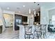 Kitchen with dark cabinets, stainless appliances, pendant lighting, gray floors opens to stairs at 11309 Grand Park Ave, Riverview, FL 33578