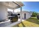 Covered patio features stone pavers, a built-in TV, and backyard with green grass at 11309 Grand Park Ave, Riverview, FL 33578