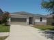 Inviting single-story home featuring a neutral color scheme, well-maintained lawn, and attached two-car garage at 11527 Southern Creek Dr, Gibsonton, FL 33534